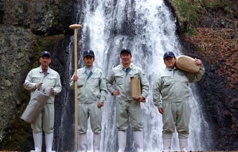 白瀑を背景に山本酒造店の4人の職人さんが写っています