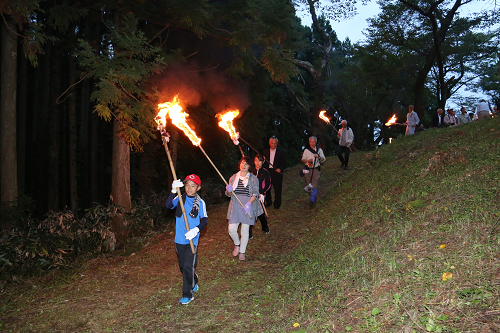 写真:たいまつを持って山道を歩く様子1