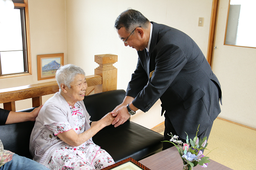 写真:越中サツヨさんが町長と握手する様子