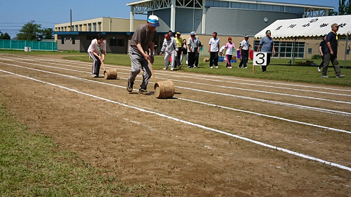 写真:樽を棒で転がすリレー