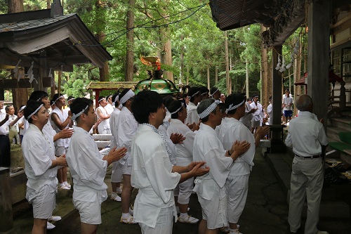 写真:神社に手を合わせる様子